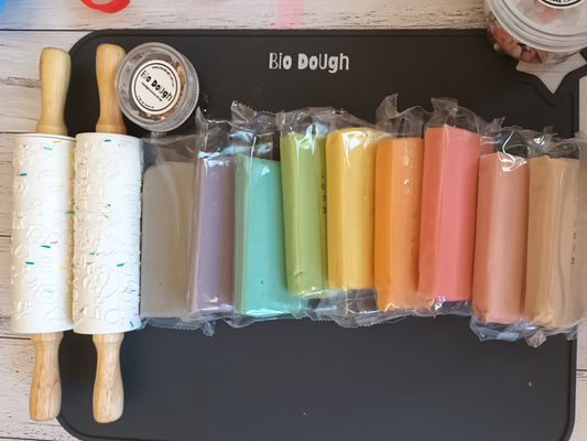 Bio DoUgh natural playdough in many colours lined up in a rainbow arrangement