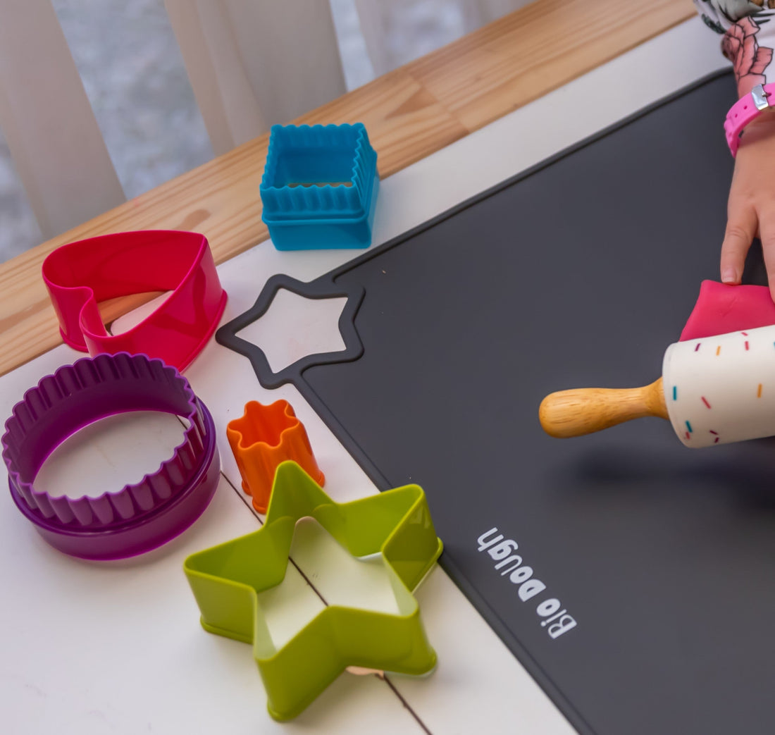 Child exploring colourful Bio DoUgh cutters, mat and rolling pin