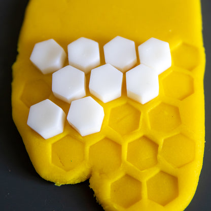 White Bio DoUgh Blocks arranged on yellow playdough in a honeycomb pattern