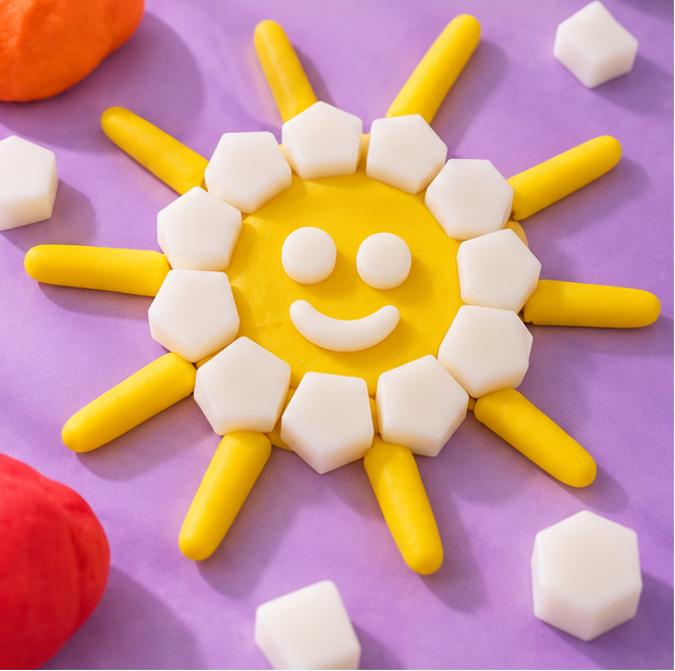 Smiling yellow playdough sun decorated with white Bio DoUgh Blocks