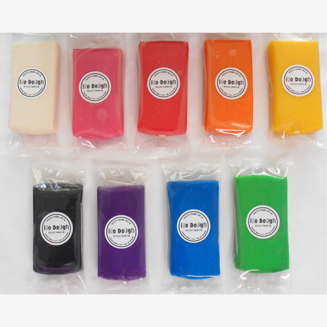 Bio DoUgh Sampler mini packs laid out in two rows showing a range of colours including white, pink, red, orange, yellow, black, purple, blue and green, each individually wrapped with a Bio DoUgh Natural Modelling label