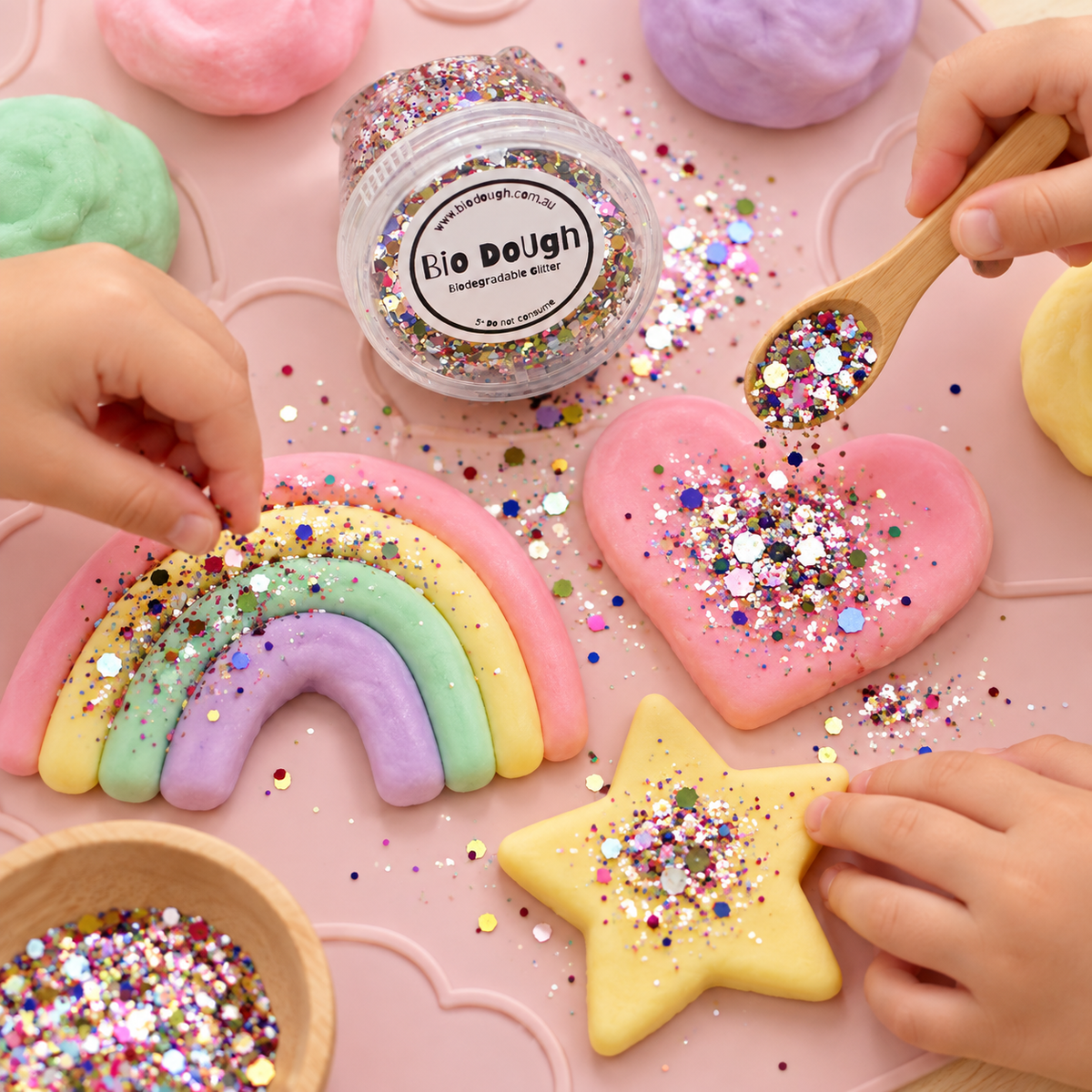 Children using Confetti Mix biodegradable glitter to decorate rainbow and star Bio DoUgh creations
