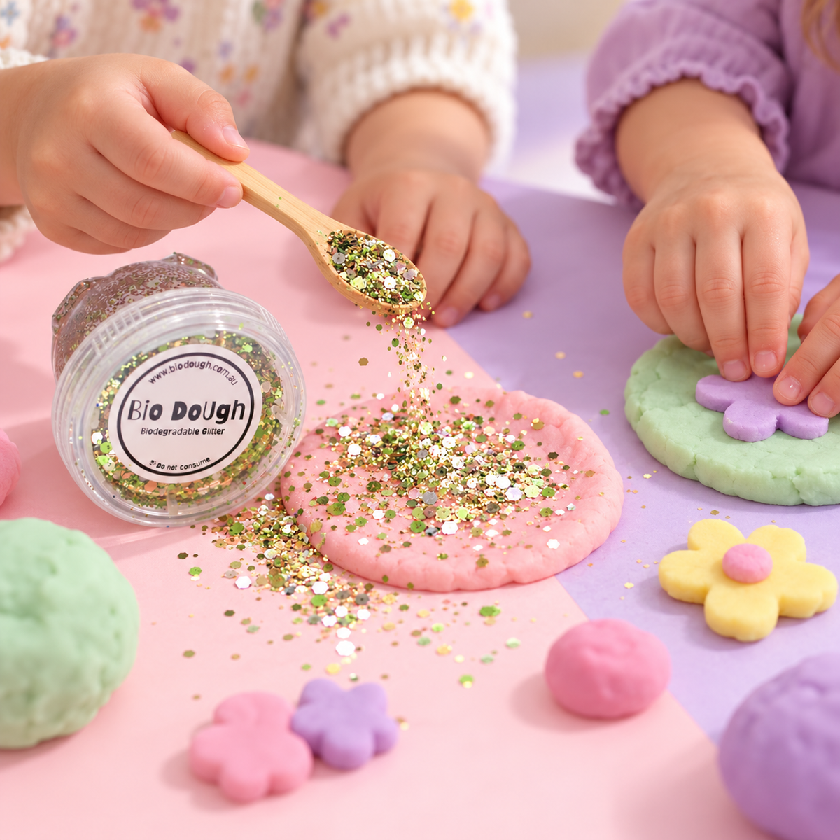 Children adding Dino Mix biodegradable glitter to colourful playdough creations