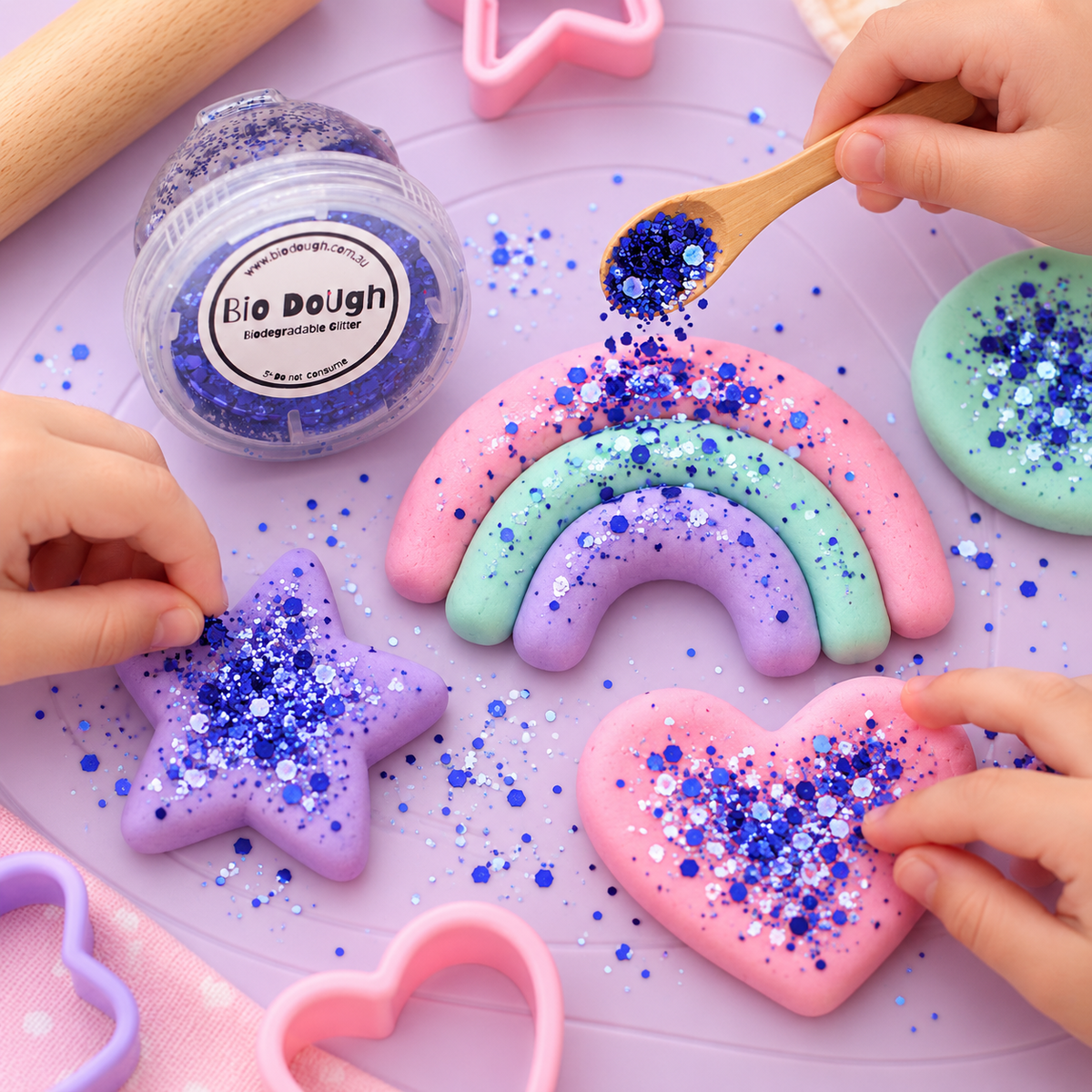 Children adding Electric Blue Bio DoUgh glitter to colourful playdough creations