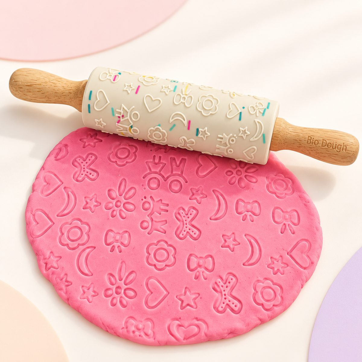 Bio DoUgh embossed silicone rolling pin creating fun patterns in pink playdough