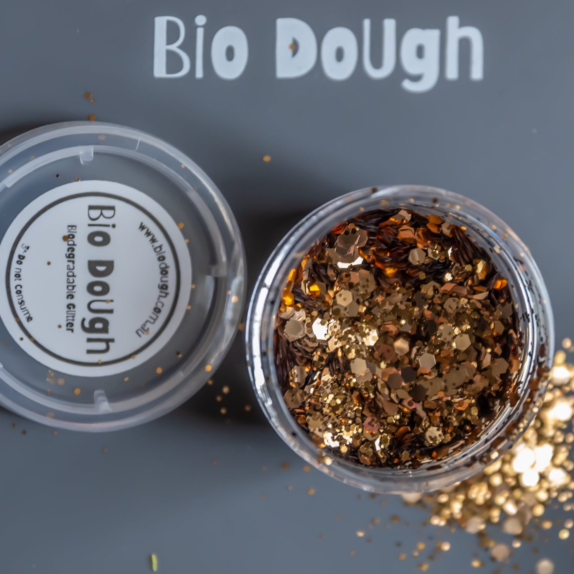 Close-up of eco-friendly golden glitter in jar for kids crafts